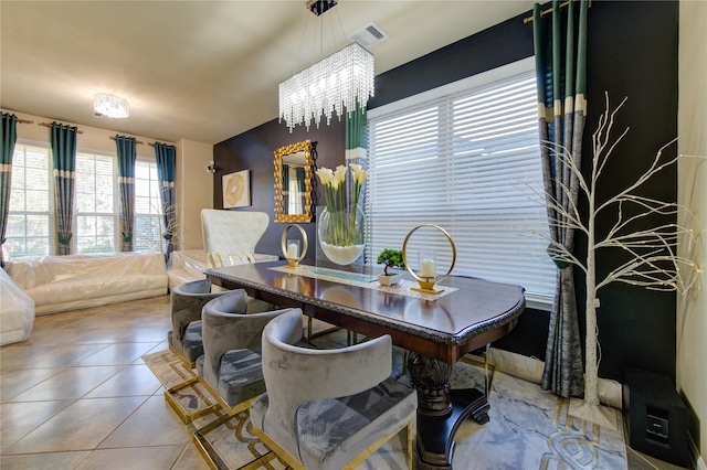 dining area with tile patterned floors and a chandelier