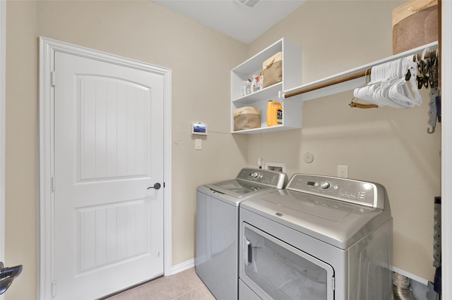 laundry room with washing machine and dryer and light tile patterned flooring