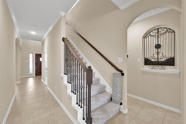 stairs with ornamental molding and tile patterned flooring