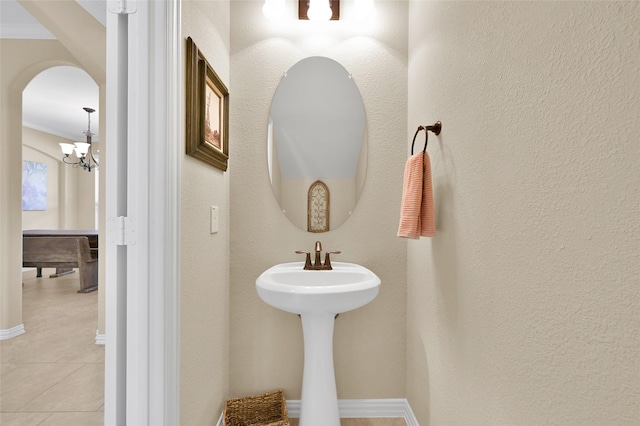 bathroom with an inviting chandelier and tile patterned floors