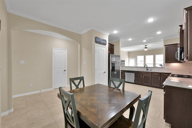 dining room with crown molding, ceiling fan, sink, and light tile patterned floors