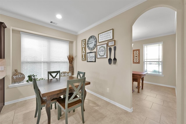 tiled dining area featuring crown molding