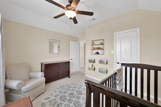 bedroom featuring vaulted ceiling, a nursery area, light colored carpet, and ceiling fan