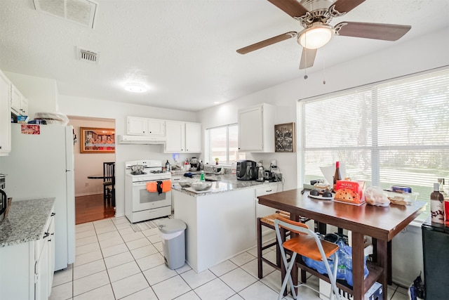 kitchen featuring white cabinetry, light stone countertops, and white appliances