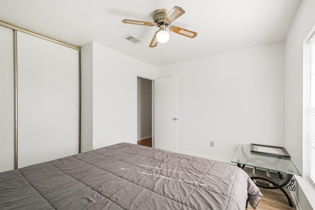 bedroom featuring ceiling fan, a closet, and wood-type flooring