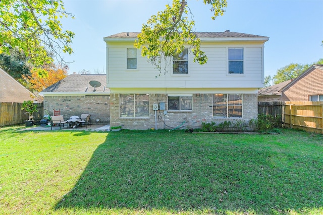 rear view of house featuring a patio area and a yard