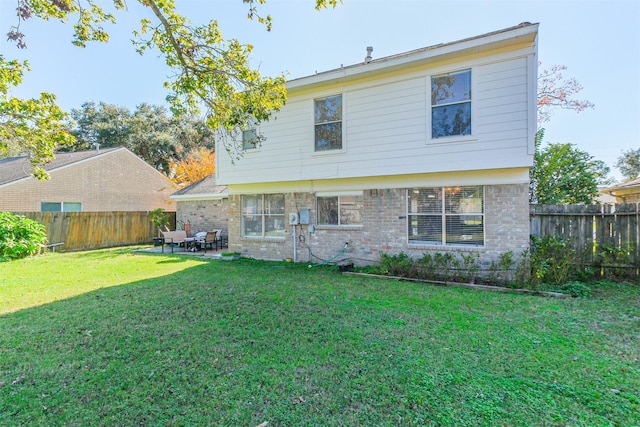 rear view of house featuring a yard and a patio