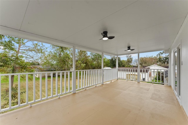 unfurnished sunroom with ceiling fan