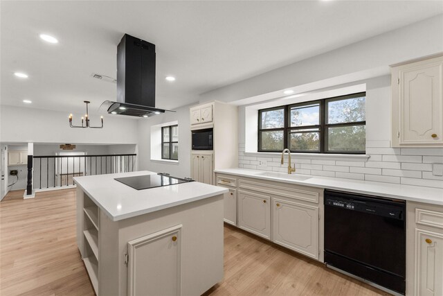 kitchen featuring sink, range hood, decorative backsplash, a kitchen island, and black appliances