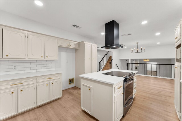 kitchen featuring backsplash, decorative light fixtures, stainless steel electric stove, white cabinets, and exhaust hood