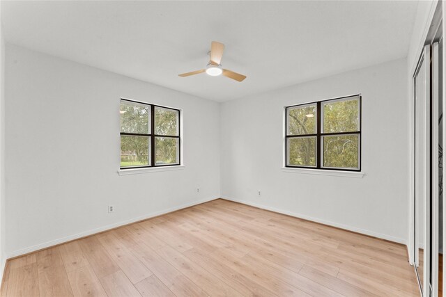 spare room with ceiling fan, a healthy amount of sunlight, and light hardwood / wood-style floors