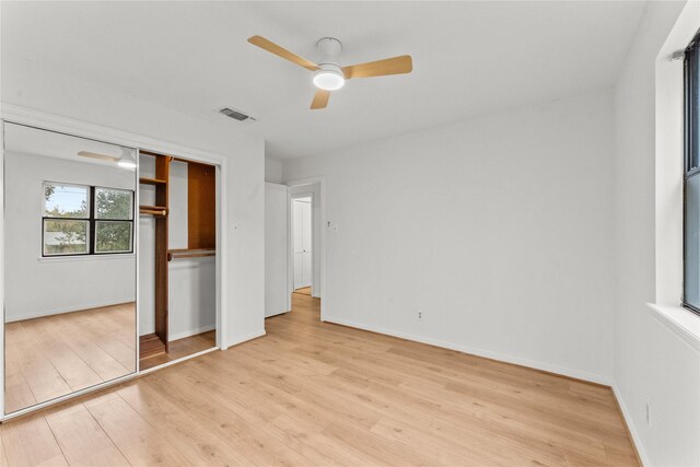 unfurnished bedroom with ceiling fan, a closet, and light wood-type flooring