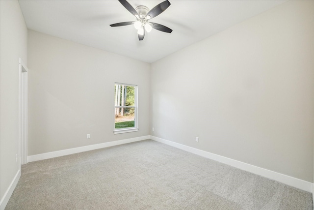 carpeted empty room featuring baseboards and a ceiling fan