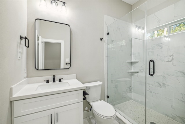 bathroom with vanity, toilet, and a shower with shower door