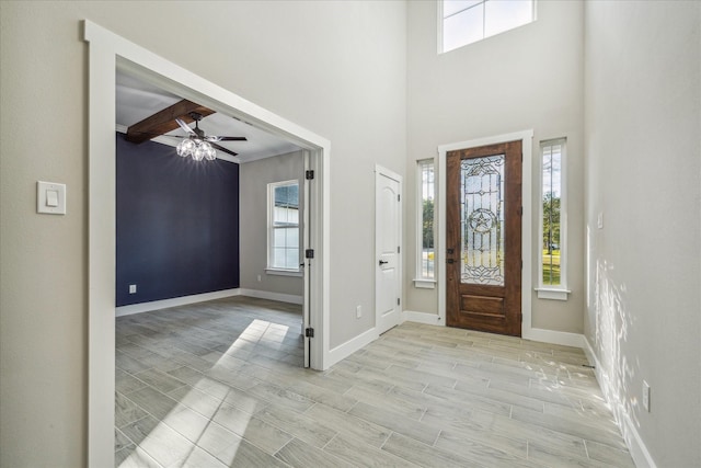 entrance foyer featuring baseboards, ceiling fan, and wood tiled floor