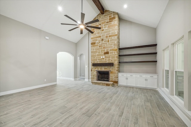 unfurnished living room featuring ceiling fan, beam ceiling, light wood-type flooring, and high vaulted ceiling