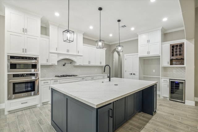 kitchen featuring visible vents, wood finish floors, wine cooler, appliances with stainless steel finishes, and white cabinetry