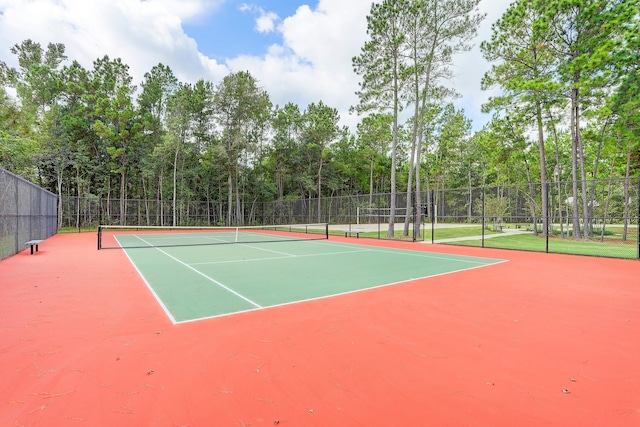 view of tennis court featuring community basketball court and fence