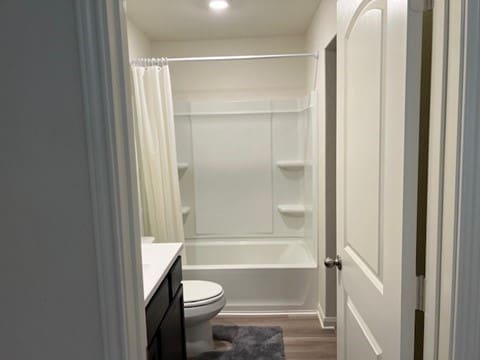 full bathroom with wood-type flooring, vanity, toilet, and shower / bathtub combination with curtain