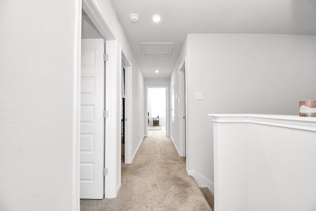 hall with light colored carpet