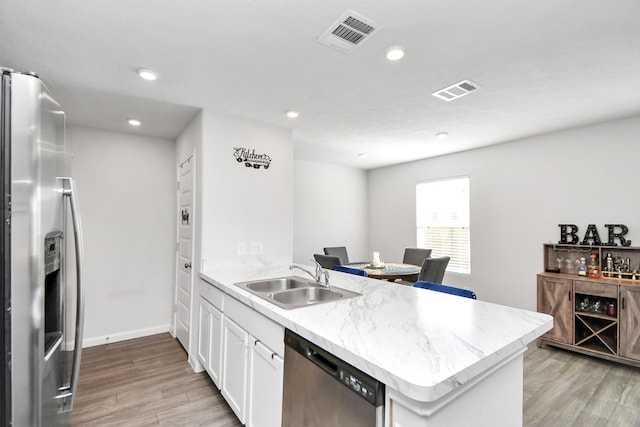 kitchen with white cabinetry, sink, stainless steel appliances, and light wood-type flooring