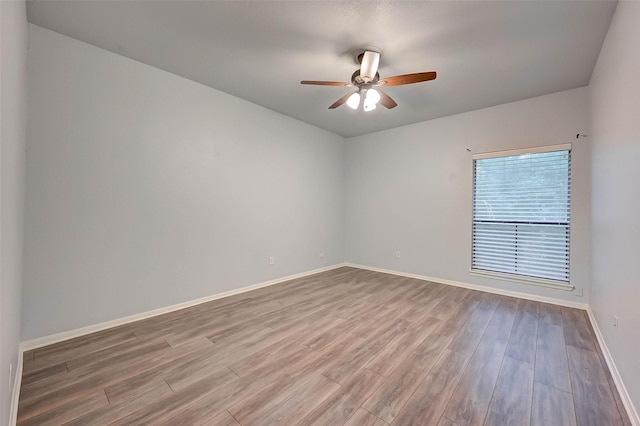 unfurnished room with ceiling fan and wood-type flooring