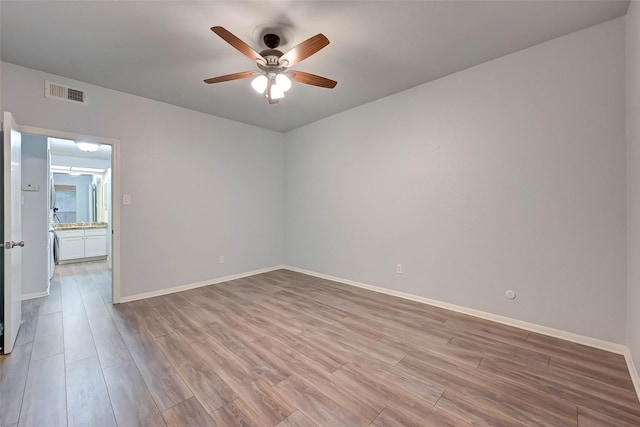 unfurnished room with washer / clothes dryer, ceiling fan, and light wood-type flooring