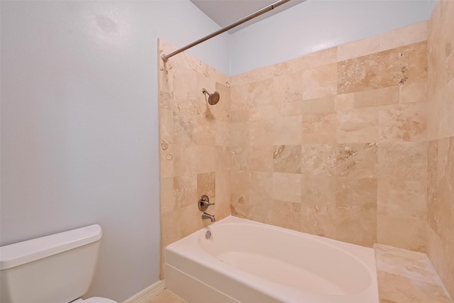 bathroom with tiled shower / bath combo and toilet