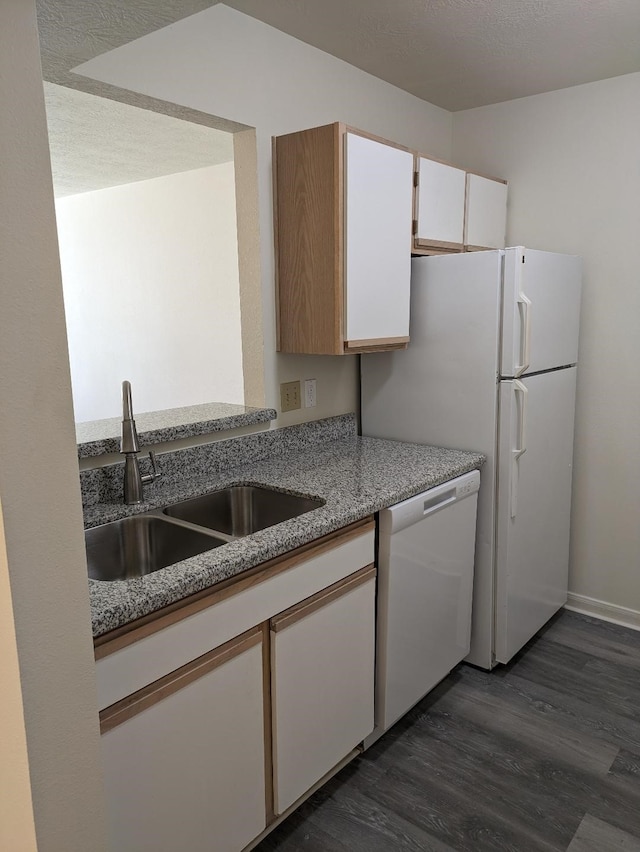 kitchen featuring white appliances, sink, dark hardwood / wood-style floors, a textured ceiling, and white cabinetry