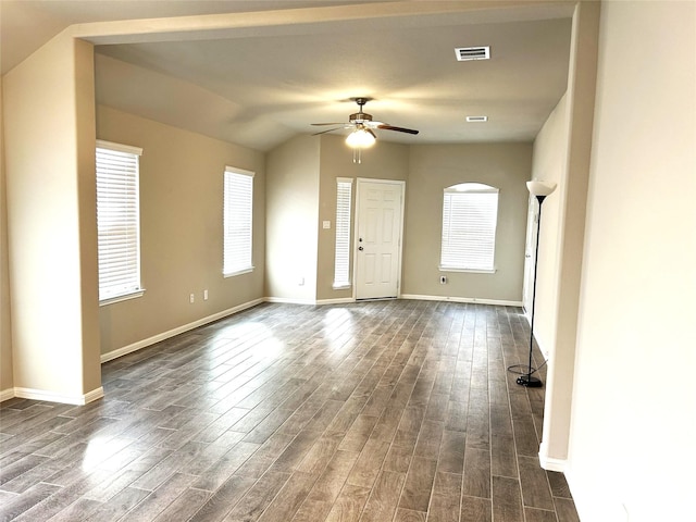 spare room featuring dark wood-type flooring, vaulted ceiling, and ceiling fan