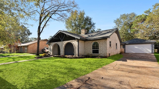 view of front of property with a garage, an outbuilding, and a front yard