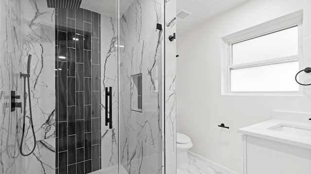 bathroom with vanity, toilet, and tiled shower