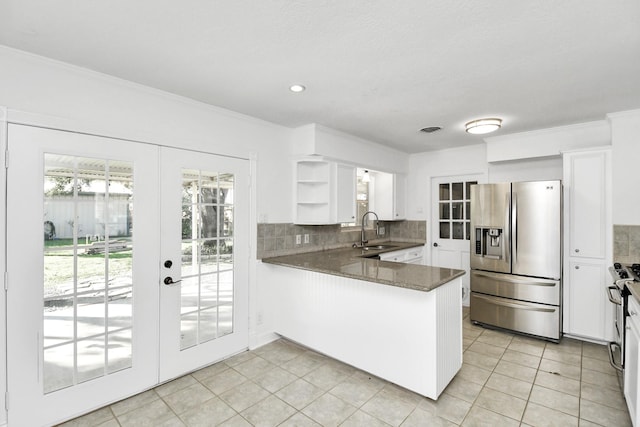 kitchen featuring french doors, sink, stainless steel fridge, kitchen peninsula, and white cabinets