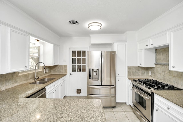 kitchen with sink, backsplash, stainless steel appliances, light stone countertops, and white cabinets