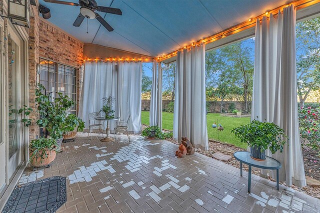 unfurnished sunroom featuring a healthy amount of sunlight, ceiling fan, and lofted ceiling