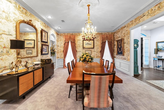 carpeted dining room featuring a chandelier and ornamental molding