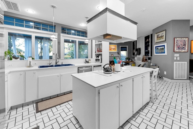 kitchen featuring a kitchen island, sink, decorative light fixtures, dishwasher, and white cabinetry