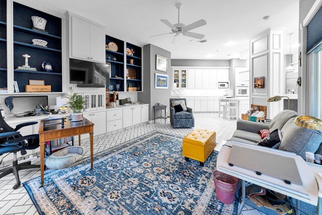 living room featuring built in shelves and ceiling fan