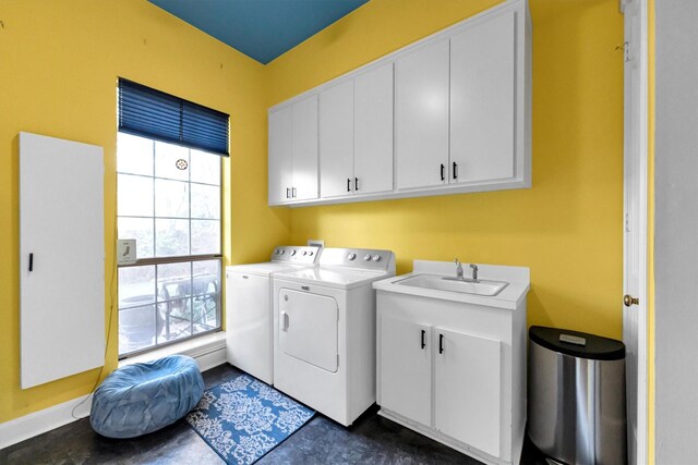 laundry area featuring cabinets, washing machine and clothes dryer, a wealth of natural light, and sink