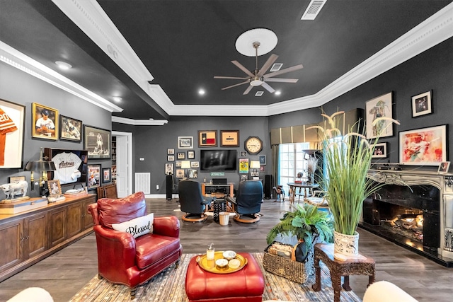 living room featuring hardwood / wood-style flooring, ornamental molding, and ceiling fan