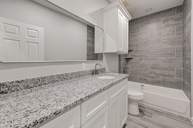 full bathroom with tiled shower / bath combo, toilet, wood-type flooring, and vanity