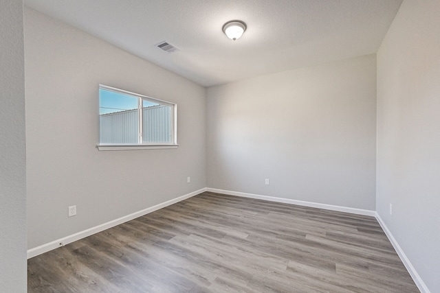 empty room with a textured ceiling and hardwood / wood-style flooring