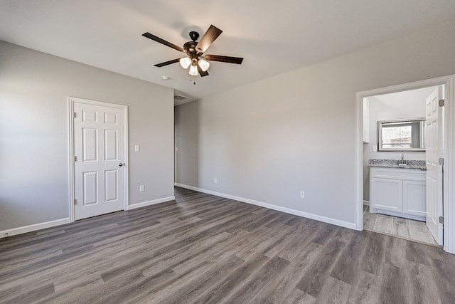 unfurnished bedroom featuring ensuite bathroom, light hardwood / wood-style flooring, ceiling fan, and sink