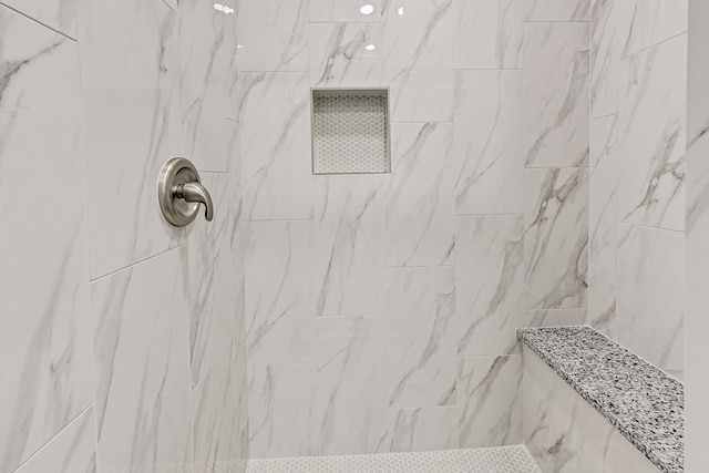 interior details featuring tiled shower