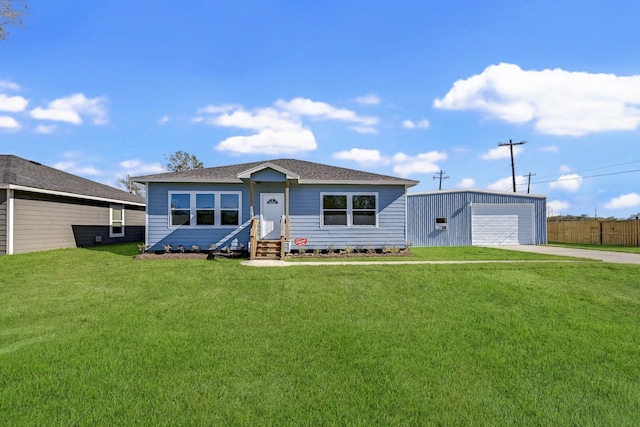 ranch-style house with a front yard, an outbuilding, and a garage