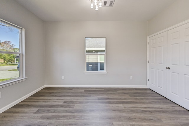 unfurnished bedroom featuring multiple windows and hardwood / wood-style flooring