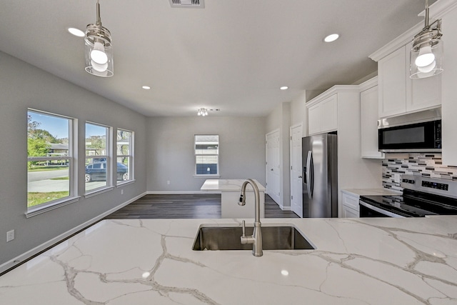 kitchen featuring pendant lighting, plenty of natural light, sink, and stainless steel appliances