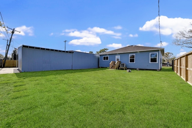 rear view of house featuring an outdoor structure and a yard