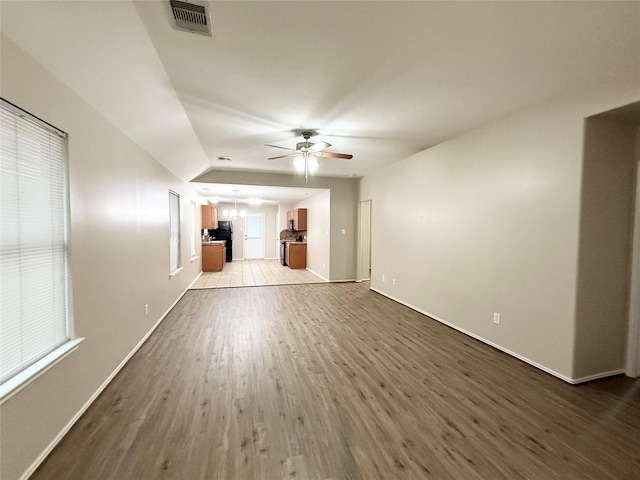 unfurnished living room featuring light hardwood / wood-style floors, ceiling fan, and lofted ceiling