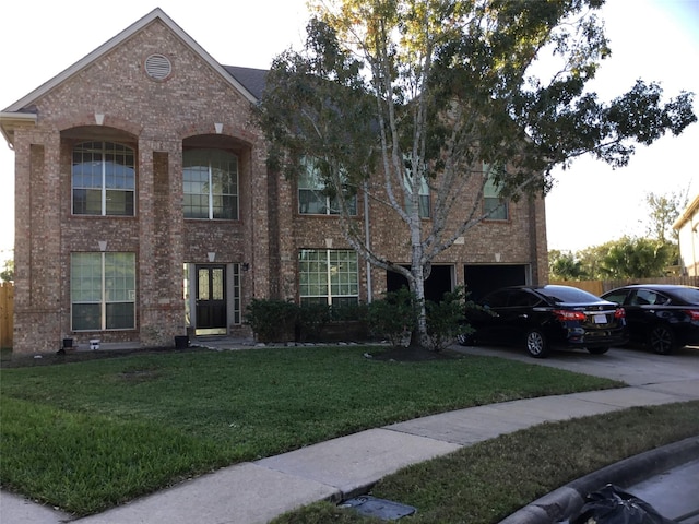 view of front of house with an attached garage, a front lawn, concrete driveway, and brick siding